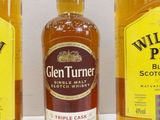 three bottles of whiskey sitting next to each other on a table