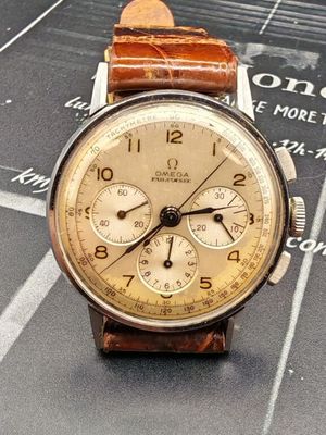 une montre posée sur une feuille de papier, sur une table