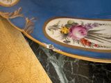 a blue plate with flowers on it sitting on a table