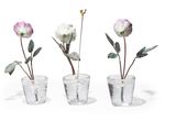 three small vases with flowers in them on a white surface