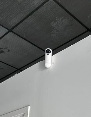 a white alarm on the ceiling of a bathroom