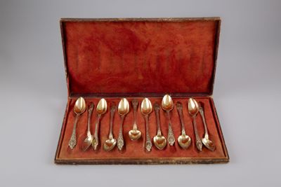 un assortiment d'argenterie dans un coffret rouge posé sur une table