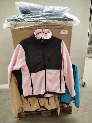 une veste rose et noire posée sur un chariot dans un entrepôt