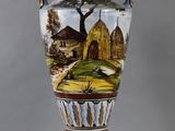 un vase avec un tableau posé sur une table