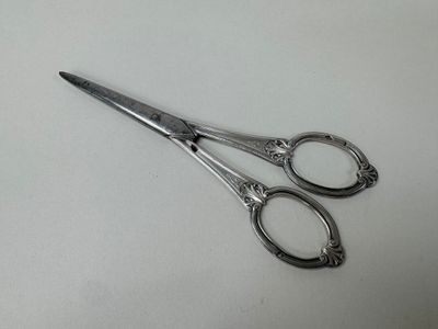 a pair of scissors sitting on a white surface