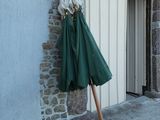 un parapluie vert appuyé contre un mur de pierre