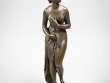 une statue en bronze représentant une femme tenant une fleur