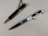 a knife and a pen on a table next to each other