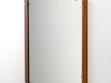 un miroir accroché au mur au-dessus d'un lavabo