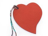 une étiquette rouge en forme de cœur à laquelle est attachée une ficelle