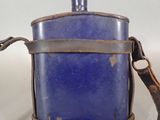a small blue flask with a brown strap on it