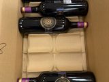 six bouteilles de vin dans un carton posé par terre