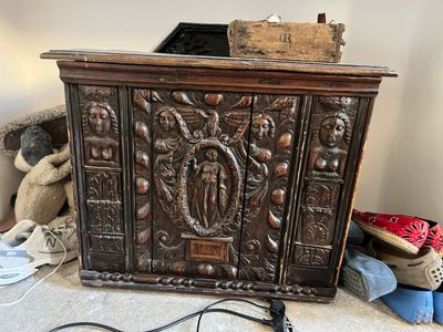 a wooden cabinet with carvings on the front of it