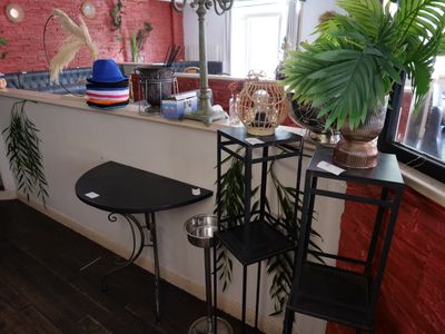 une petite table sur laquelle est posé un chapeau, près d'une fenêtre