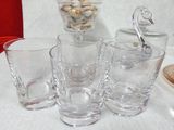bottles and glasses are lined up on a white table cloth
