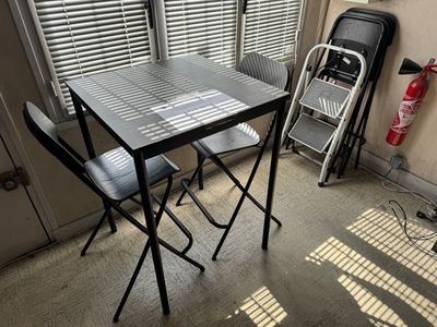 une petite table et des chaises dans un coin de la pièce