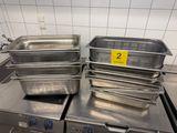 Plusieurs casseroles en acier inoxydable sont empilées les unes sur les autres dans une cuisine