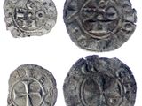 quatre pièces d'argent ornées de symboles, notamment une croix et un lion