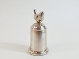 a silver bell with a bird on top of it