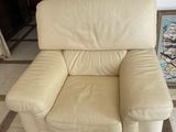 a beige leather chair in a living room with a rug