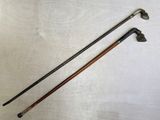 pair of antique walking canes with wooden handles on a white surface