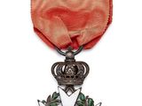 gros plan d'une médaille sur fond blanc avec un ruban rouge