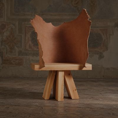 une chaise en bois avec une assise en cuir marron, posée sur un piètement en bois