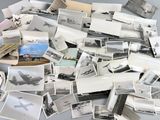 a pile of old photos of airplanes on a table