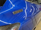 a close up of a blue car with a sticker on it