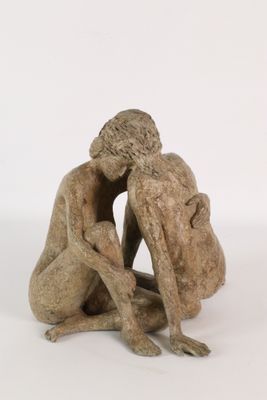 statue of a man and a woman sitting on a white surface