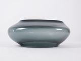 a gray vase that is sitting on a white surface