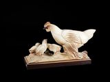 une sculpture blanche représentant un oiseau et deux oiseaux posés sur une table