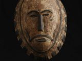 un gros plan d'un masque en bois sur fond noir