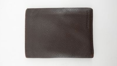 un portefeuille marron posé sur une table blanche