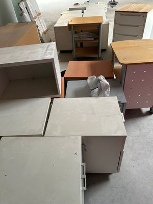 plusieurs bureaux et armoires dans une pièce, avec un chat assis sur l'un d'entre eux