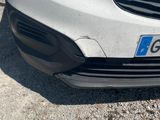 the front end of a white car with a number plate on it