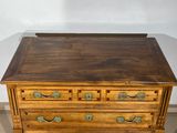 a wooden chest of drawers with brass handles on it