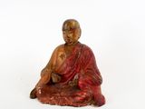 statue représentant une personne assise en position de méditation sur une surface blanche