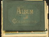 un vieil album à la couverture verte posé au sommet d'une pile de livres