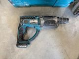 an electric drill is laying on the floor next to a blue box