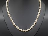 un collier de perles blanches sur un mannequin noir