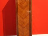 an image of a tall wooden cabinet against a red wall