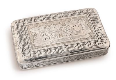 une boîte ancienne en argent sur laquelle est représenté un château