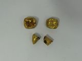 three pieces of gold are shown on a white surface