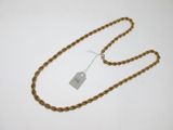une chaîne en or à laquelle est accrochée une médaille, posée sur une surface blanche