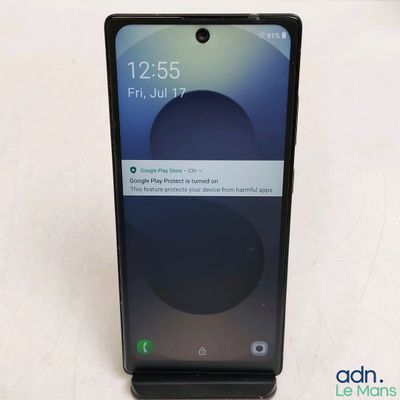 a close up of a cell phone on a white surface
