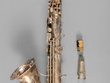 a saxophone that is laying on the ground next to a toothbrush