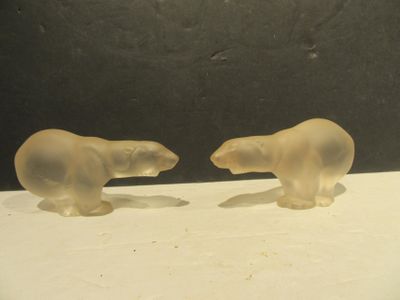 deux ours polaires en verre posés sur une surface blanche