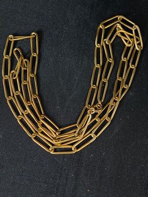 un gros plan d'un collier à chaîne en or sur fond noir