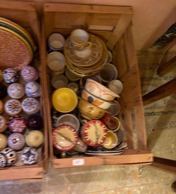 de nombreux bols et assiettes dans une caisse en bois posée par terre